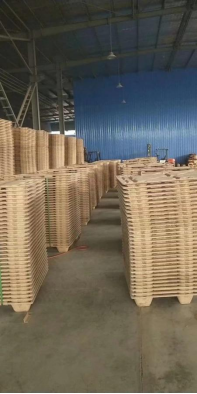 Low-angle shot of stacked pressed wood pallets ID-3025 | High stacking capacity optimizes warehouse space utilization