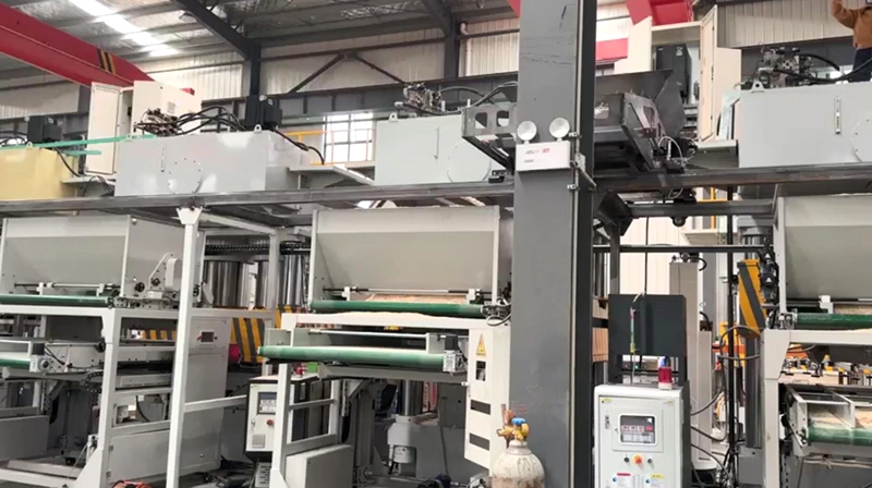 Automated dosing and spreading equipment for a molded pallet production line