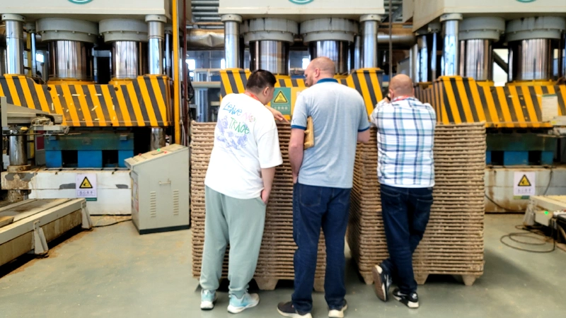 Compressed wood pallet machine quality inspection: technicians inspecting finished molded pallets