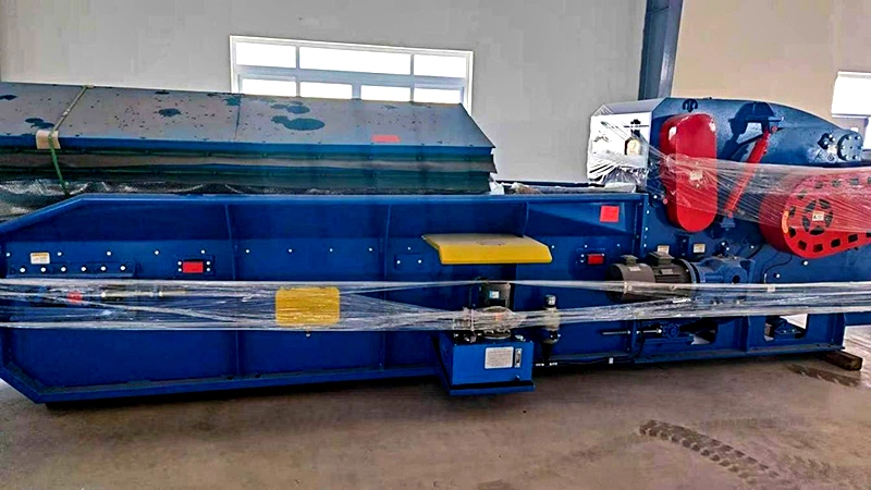 Heavy-duty timber hammer mill wood crusher at the recovery intake of a wood waste recycling machine line feeding a compressed wood pallet machine.