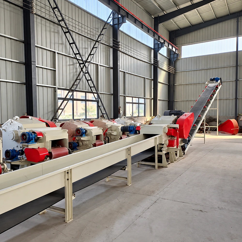 Electric wood chipper line with red feed rollers, blue electric drive motors and belt conveyor in an export pallet plant