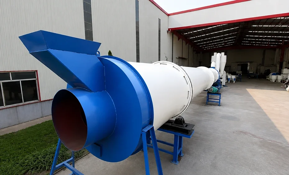 Industrial rotary drum dryer with blue feed hopper, white cylindrical shell, and roller supports