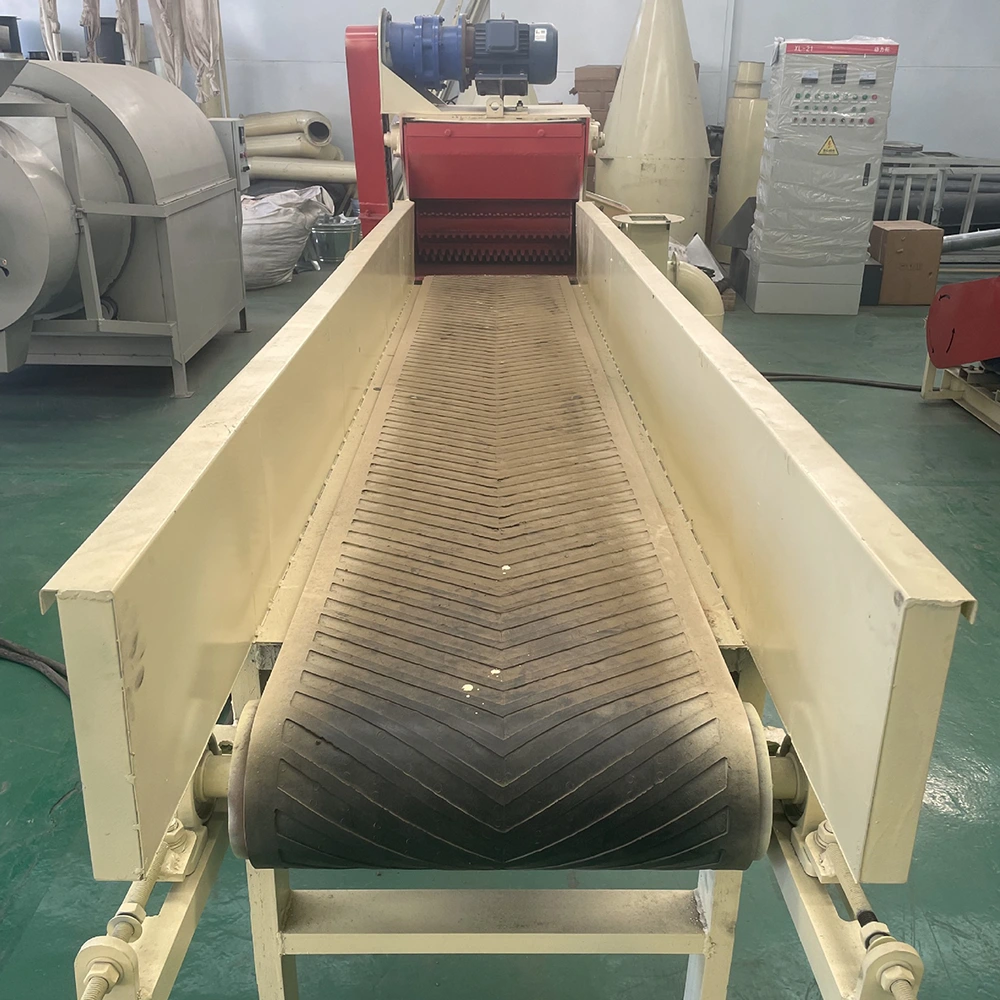 Industrial shredder infeed conveyor with chevron belt, guarded sides, and top-mounted gear motor