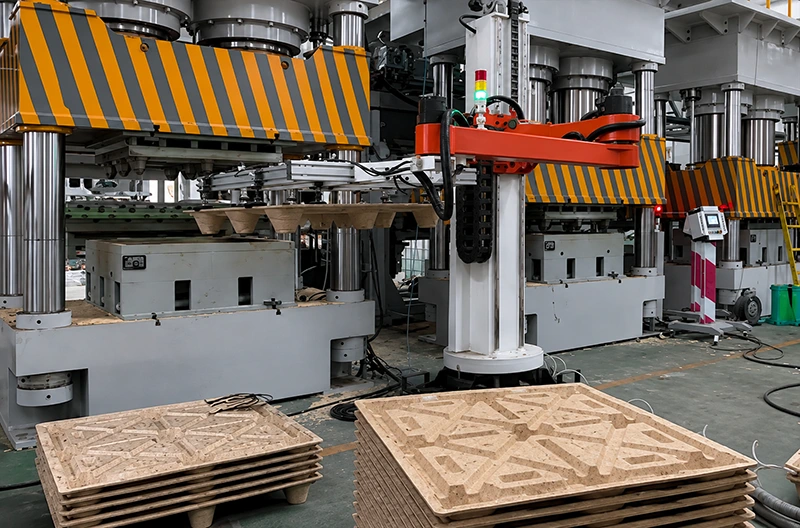 Automated hydraulic press line with robotic transfer arm and stacked embossed panels in factory