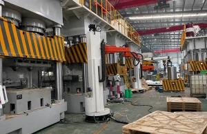 Heavy-duty hydraulic press line in factory, with guarded platen, multi-cylinder frame, and installation setup.