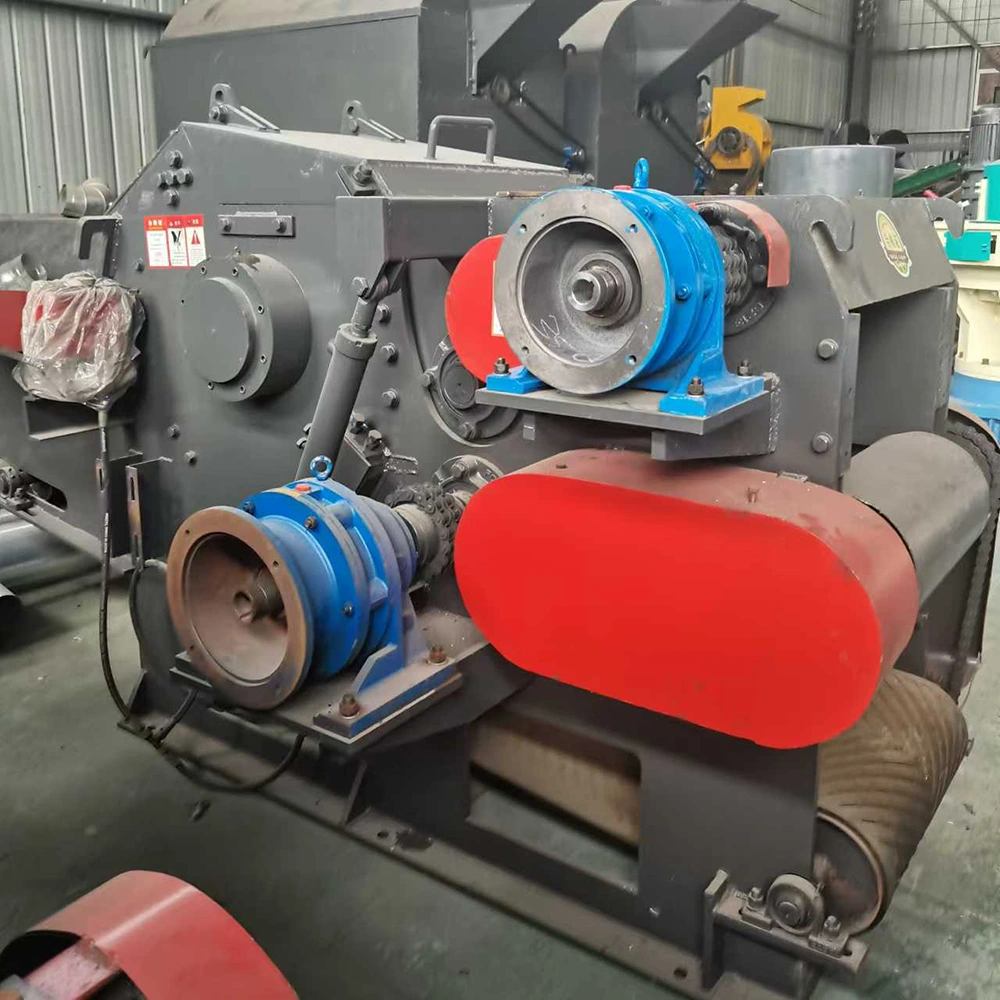 Industrial shredder frame with dual bearing blocks, red belt guards and enclosed heavy-duty steel housing on a stationary wood chipper machine