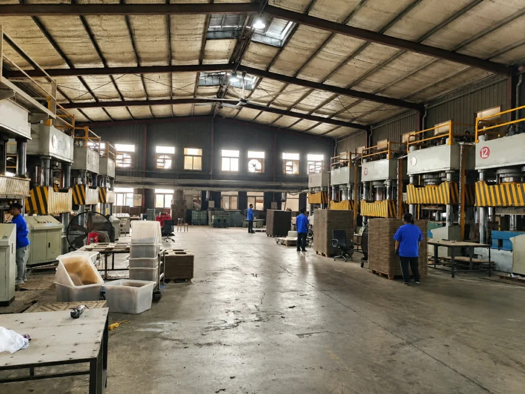 Wood pallet hydraulic press stations arranged in a row on a molded pallet production line floor with safety guards and control cabinets