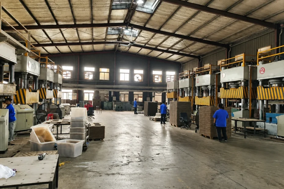 Wood pallet hydraulic press stations arranged in a row on a molded pallet production line floor with safety guards and control cabinets